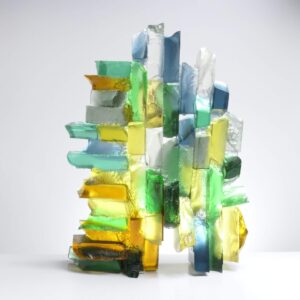Handmade glass sculpture in blues, yellows and greens and formed as a harbour wall
