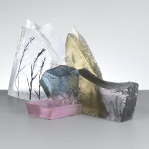 Glass sculpture in pastel colours in the form of a rocky outcrop with engraved grasses as a decoration
