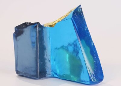 Handmade glass sculpture in the form of a fallen wall in light and dark blue with gold leaf