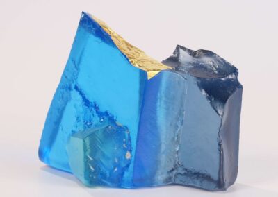 Handmade glass sculpture in the form of a fallen wall in light and dark blue with gold leaf