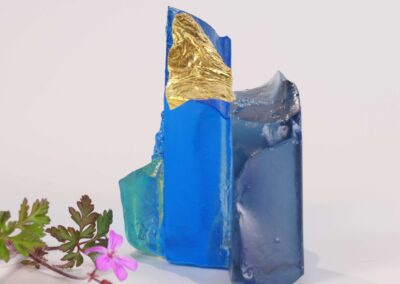 Handmade glass sculpture in the form of a fallen wall in light and dark blue with gold leaf