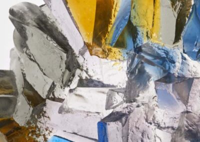 Abstract modern sculpture with gold, silver, and blue elements, showcasing contemporary art design.