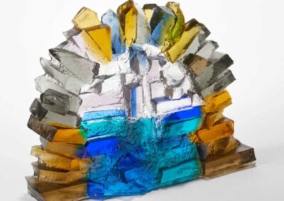 Vibrant glass art sculpture featuring colourful glass fragments and water, showcasing creative craft.