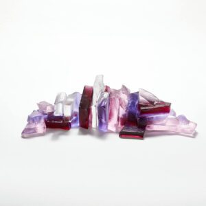 A glass sculpture in pinks of a rocky outcrop under a pink sunset