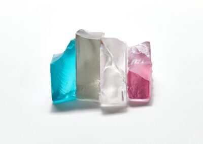 glass sculpture with blue, clear, and pink tint, minimalist style, close-up.