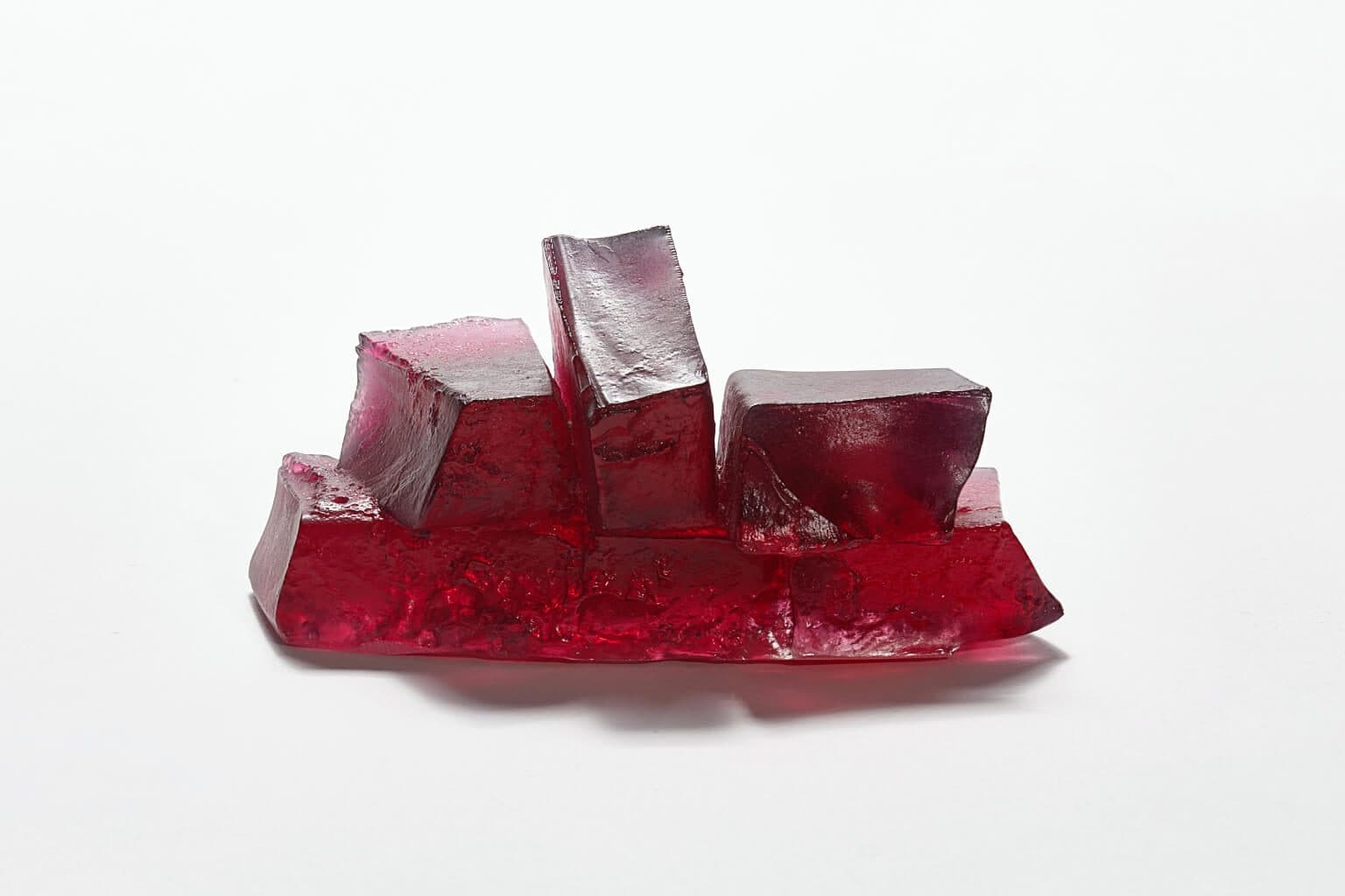 Red glass art sculpture with geometric blocks, modern design, and artistic craftsmanship.