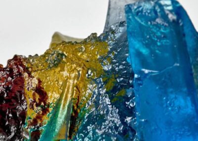 Detail of a glass sculpture suggesting a rocky outcrop in the sea at sunset.