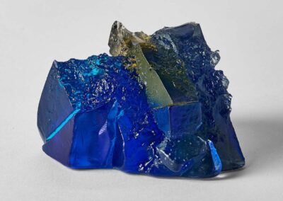 A rocky outcrop under blue sky and sun, sculpture by Deborah Timperley