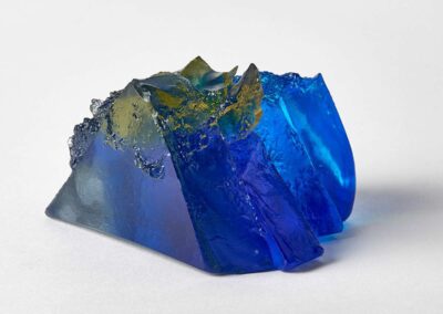 A rocky outcrop under blue sky and sun, sculpture by Deborah Timperley
